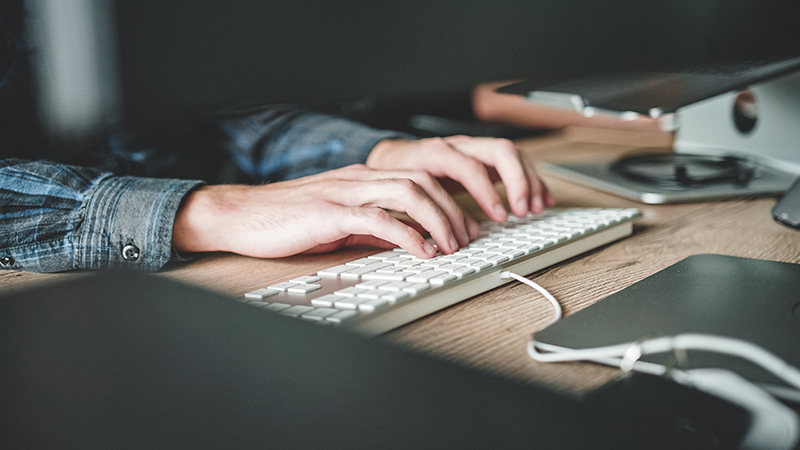 Person using a computer keyboard.