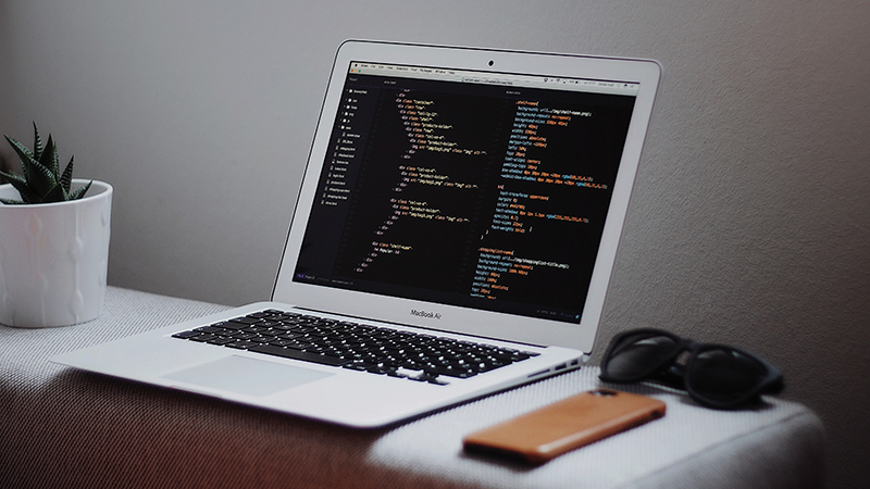 Source code displayed in a white laptop.